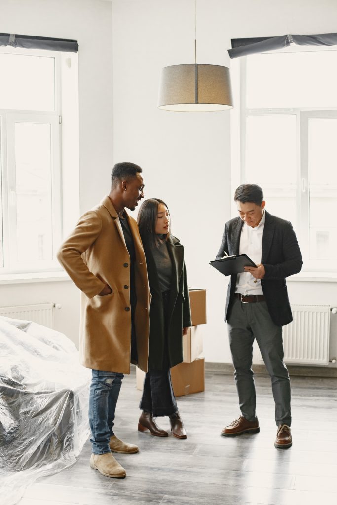 Young Couple Buying A New House. Asian woman and African man. Signing documents at new home